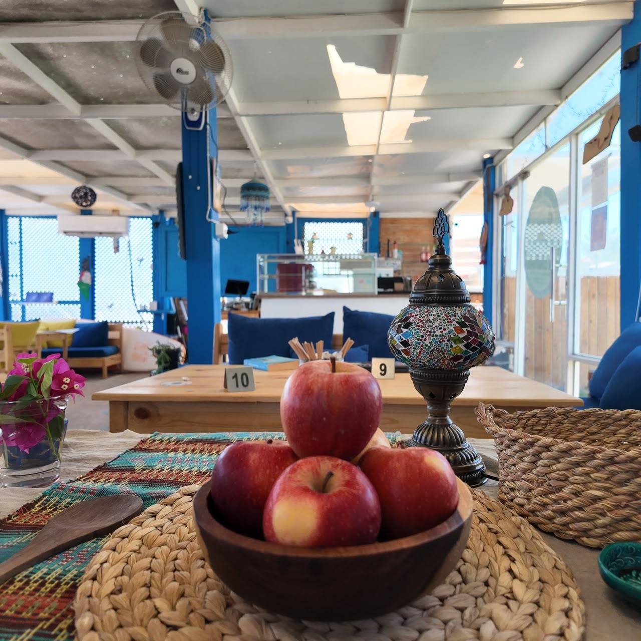 The blue and wooden dining room, with a bowl of apples and a Tunisian lantern on the table