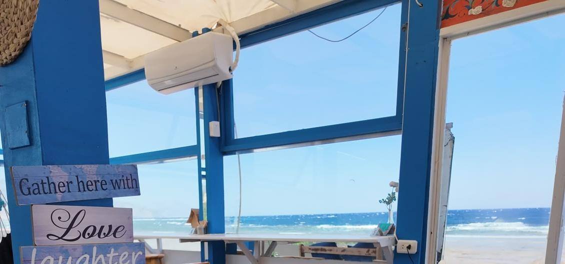 Window counter facing the Red Sea, with an air conditioner above and a power socket on the post
